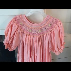 Adorable coral smocked dress with flower detail!